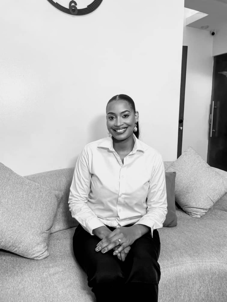 Coach Glory Osikoya smiling, seated on a sofa